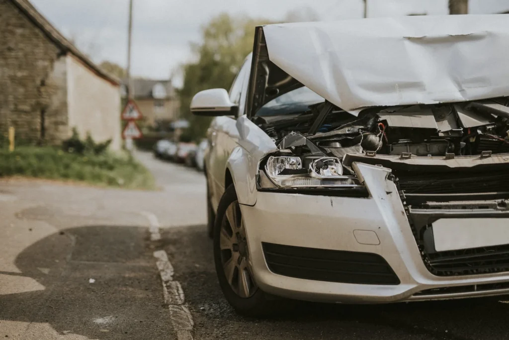 The front-end of a white car is crushed from a car accident.